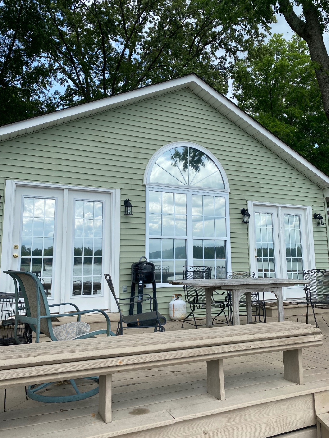 Lakeside home with a large arched window and French doors fitted with window film
