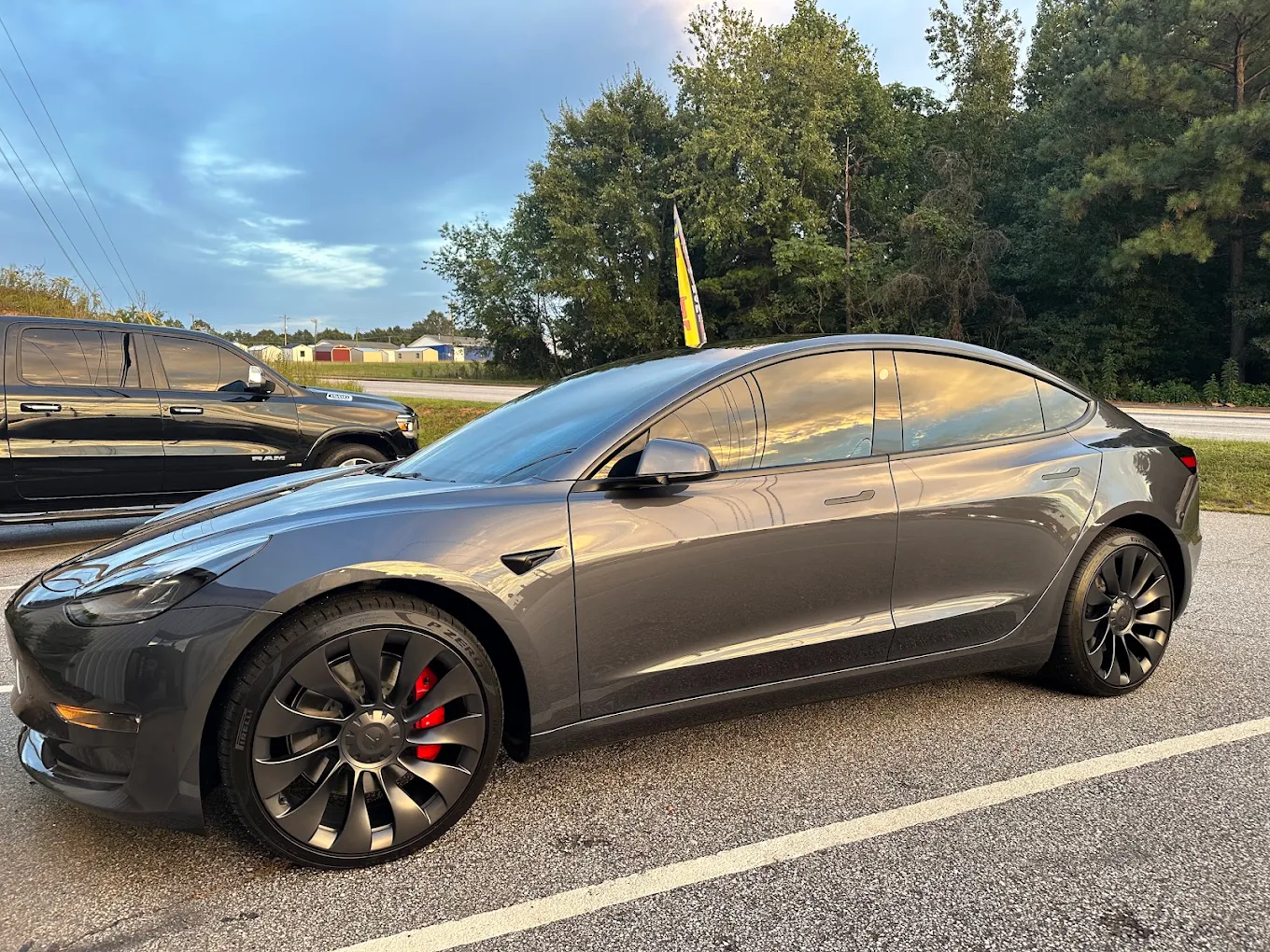 Grey Tesla Model 3 with completed window tint parked at dusk