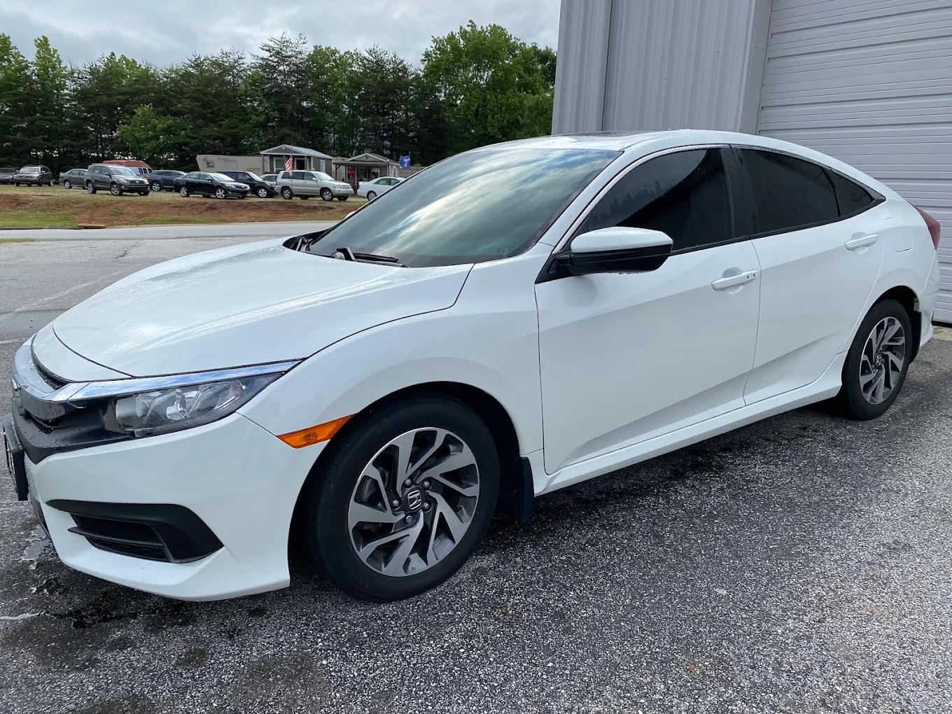 White Honda Civic with completed window tint outside the shop