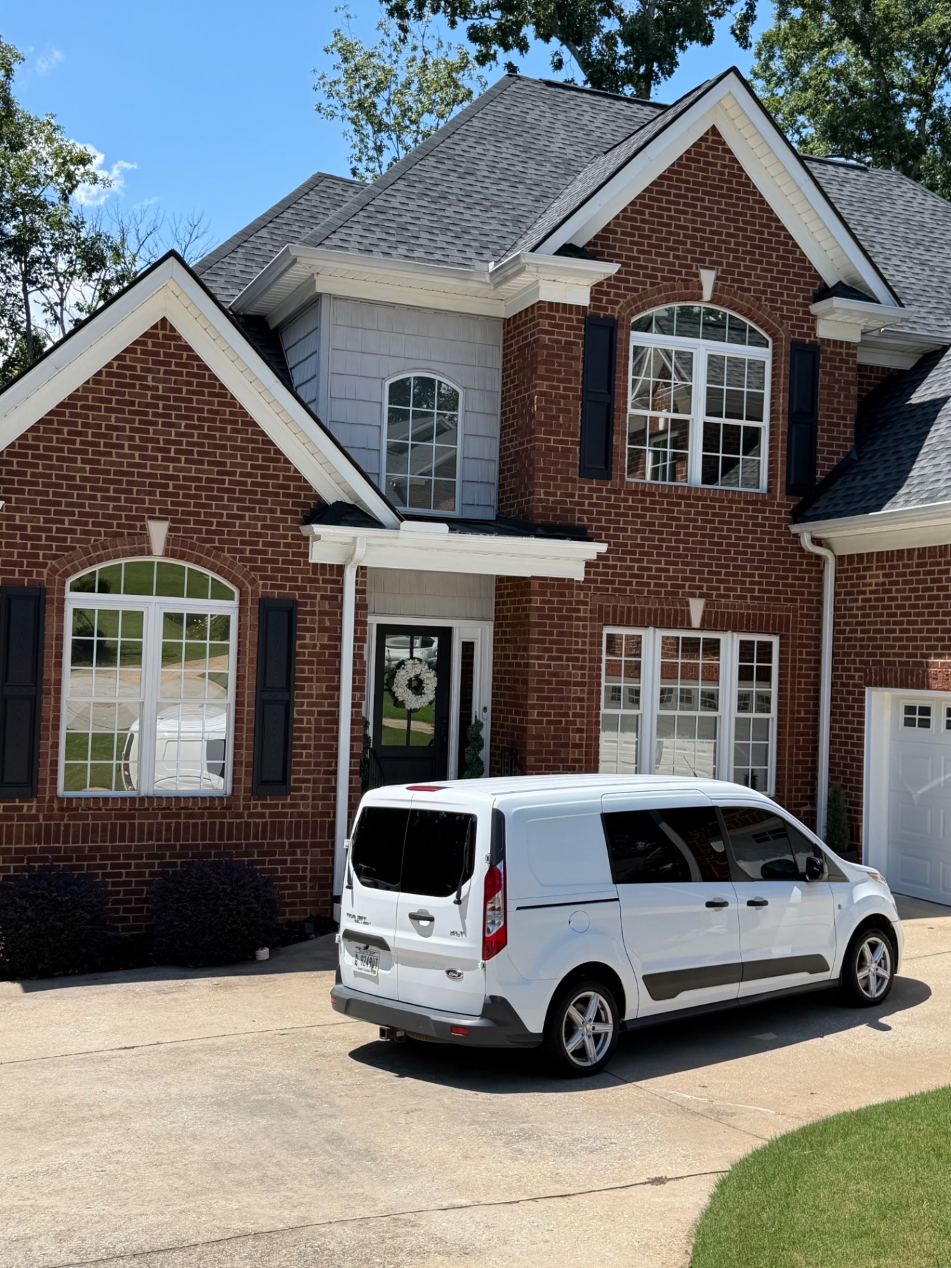 Brick home with window film installed, Greenville Pro Tint van in the driveway