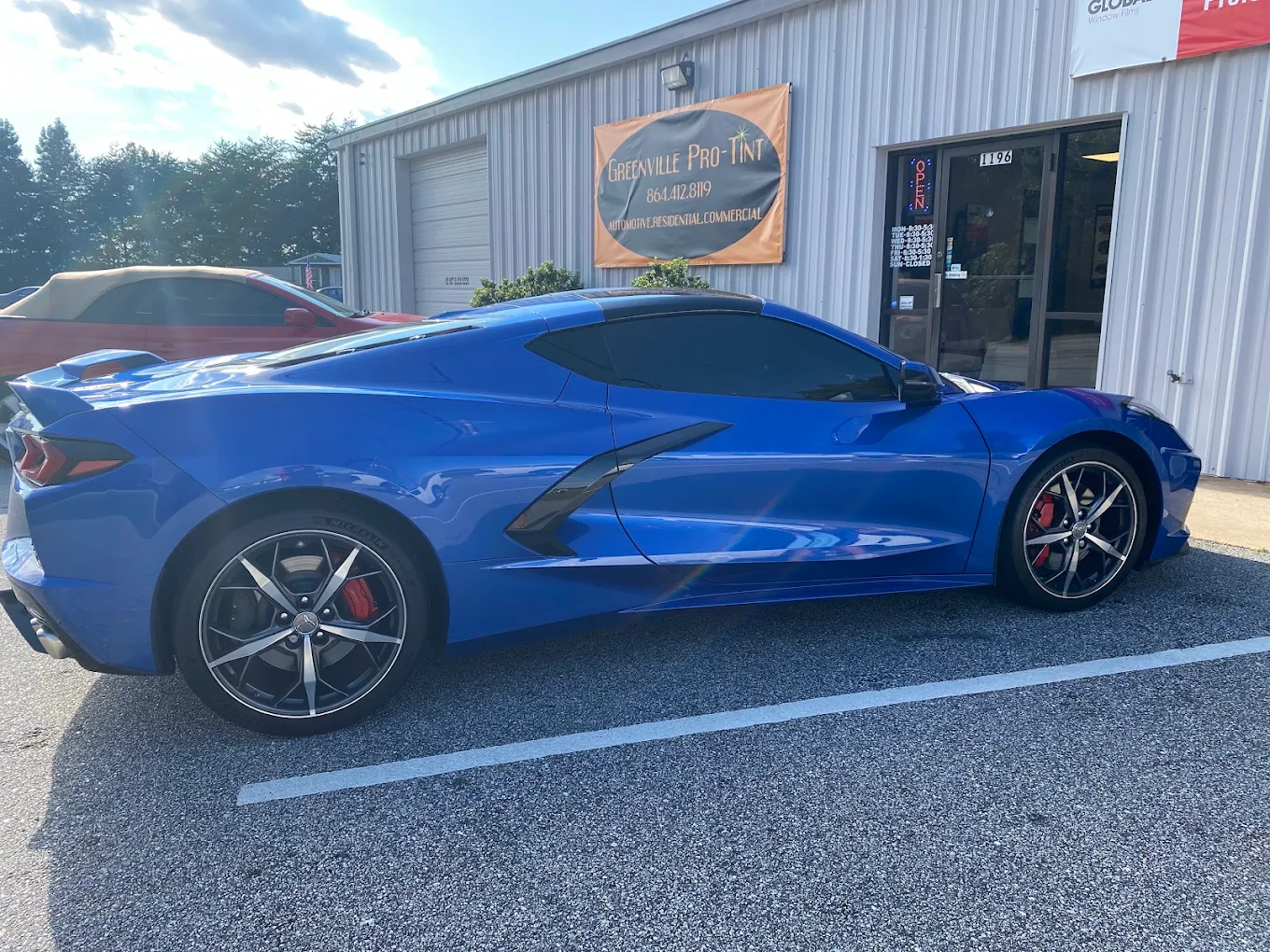 Blue Chevrolet Corvette with completed window tint outside the shop